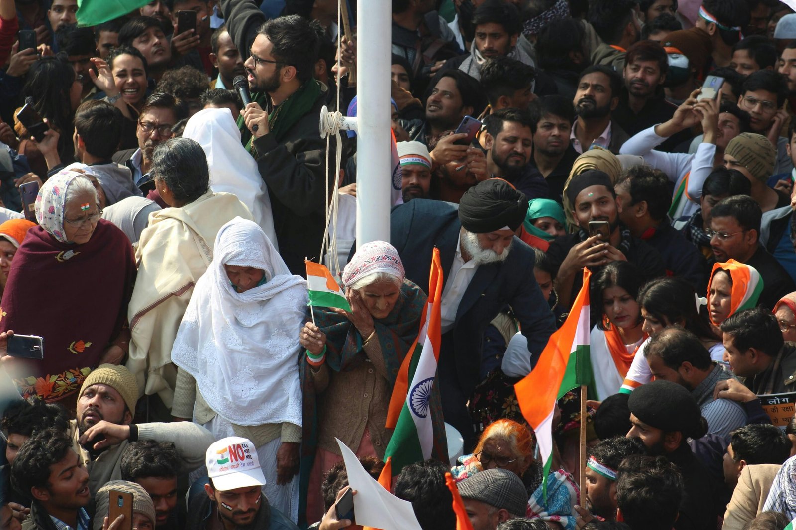 A colorful and lively Indian parade with people holding national flags and celebrating together.